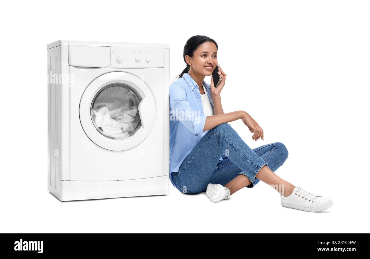 Mujer Que Mira La Ropa Blanca Cerca De La Máquina De Lavar Fotos