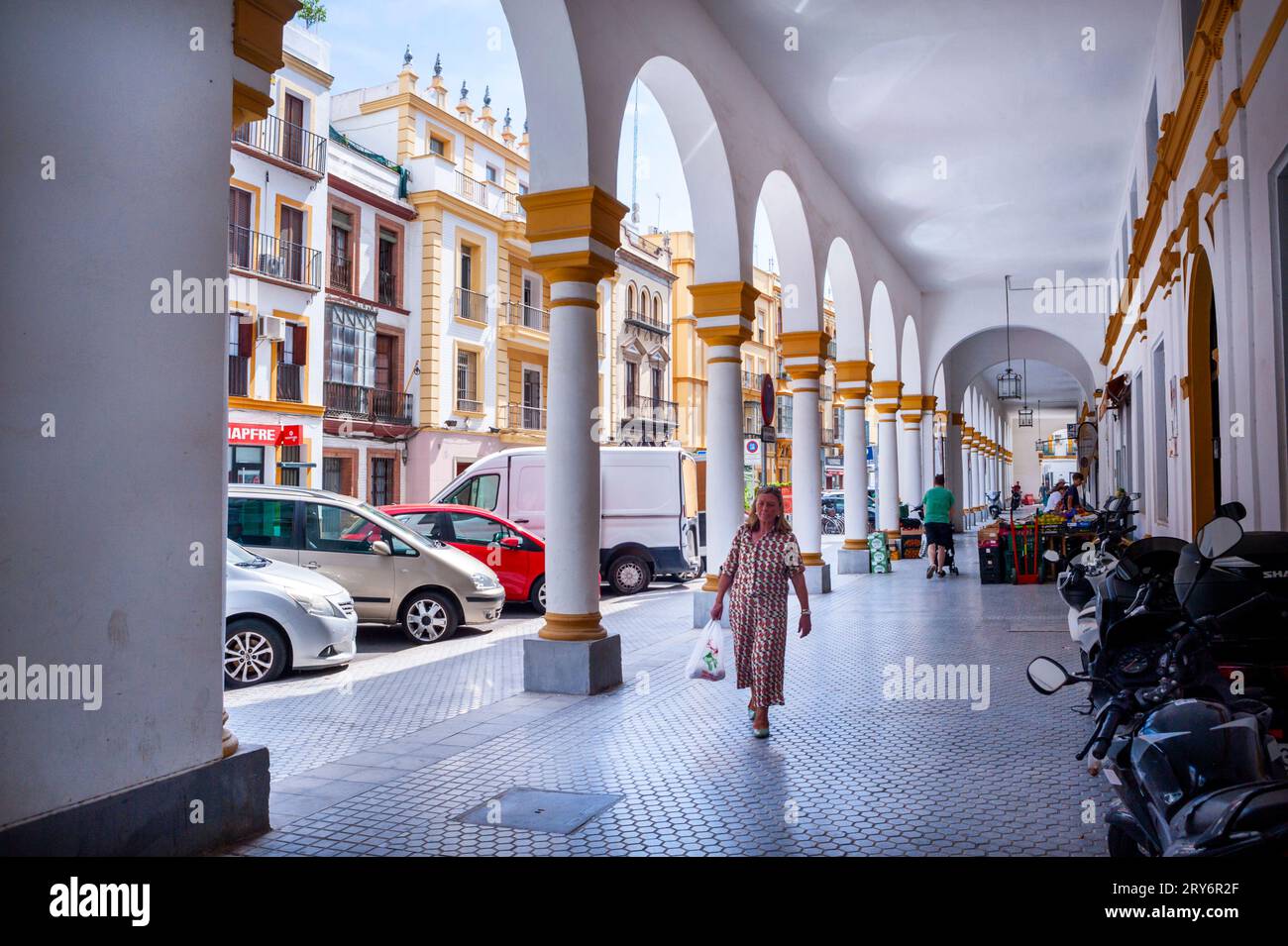 Sevilla, España, Mujer caminando, Calle exterior, Arcos, mercado Público de Alimentos, 'El Arenal Market', en el Centro de la Ciudad Vieja, Foto de stock