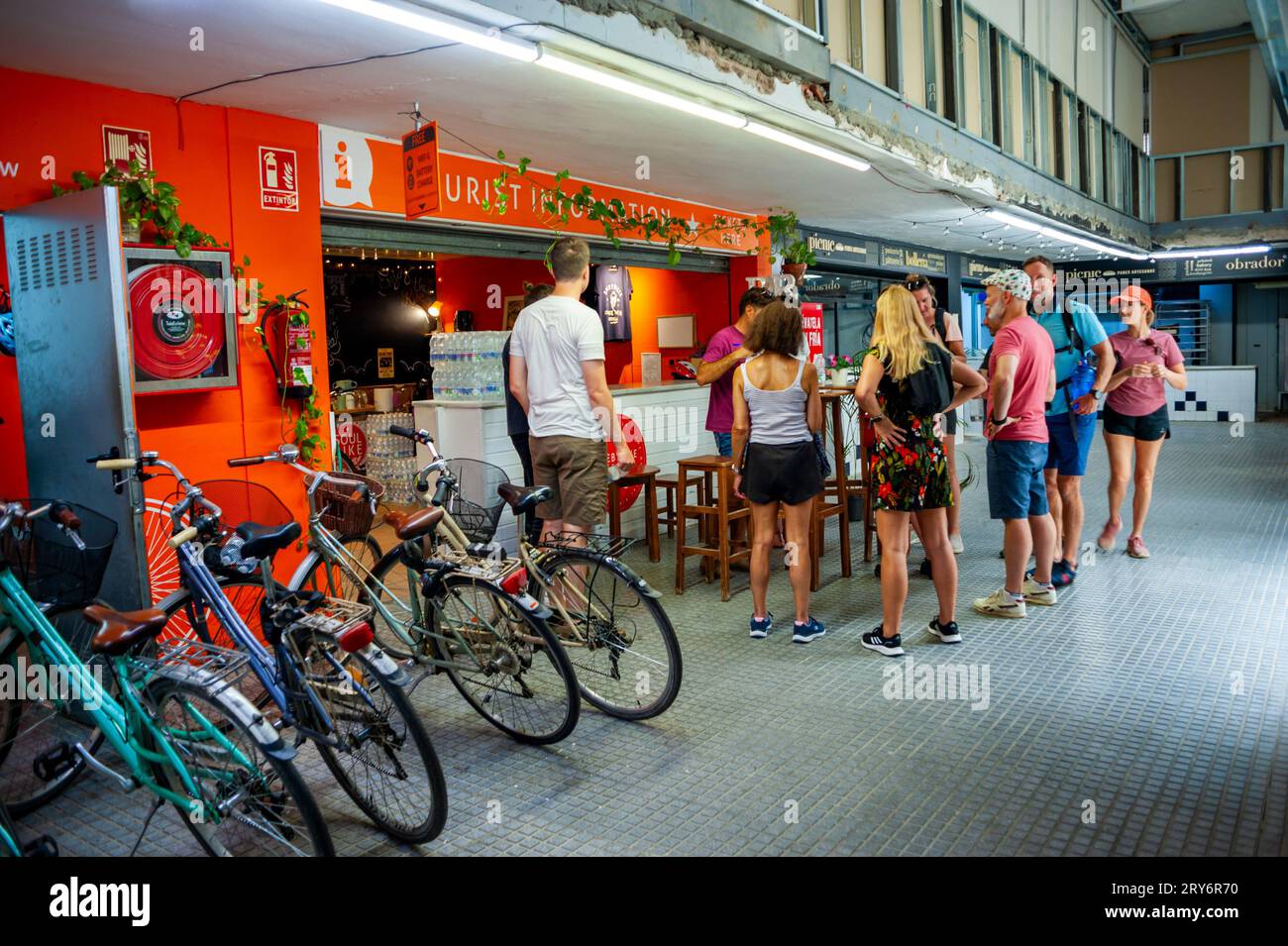 Sevilla, España, Gran multitud, Jóvenes turistas dentro de la tienda de alquiler de bicicletas, en el mercado público, 'El Arenal Market', en el centro de la ciudad vieja, ciclismo urba Foto de stock