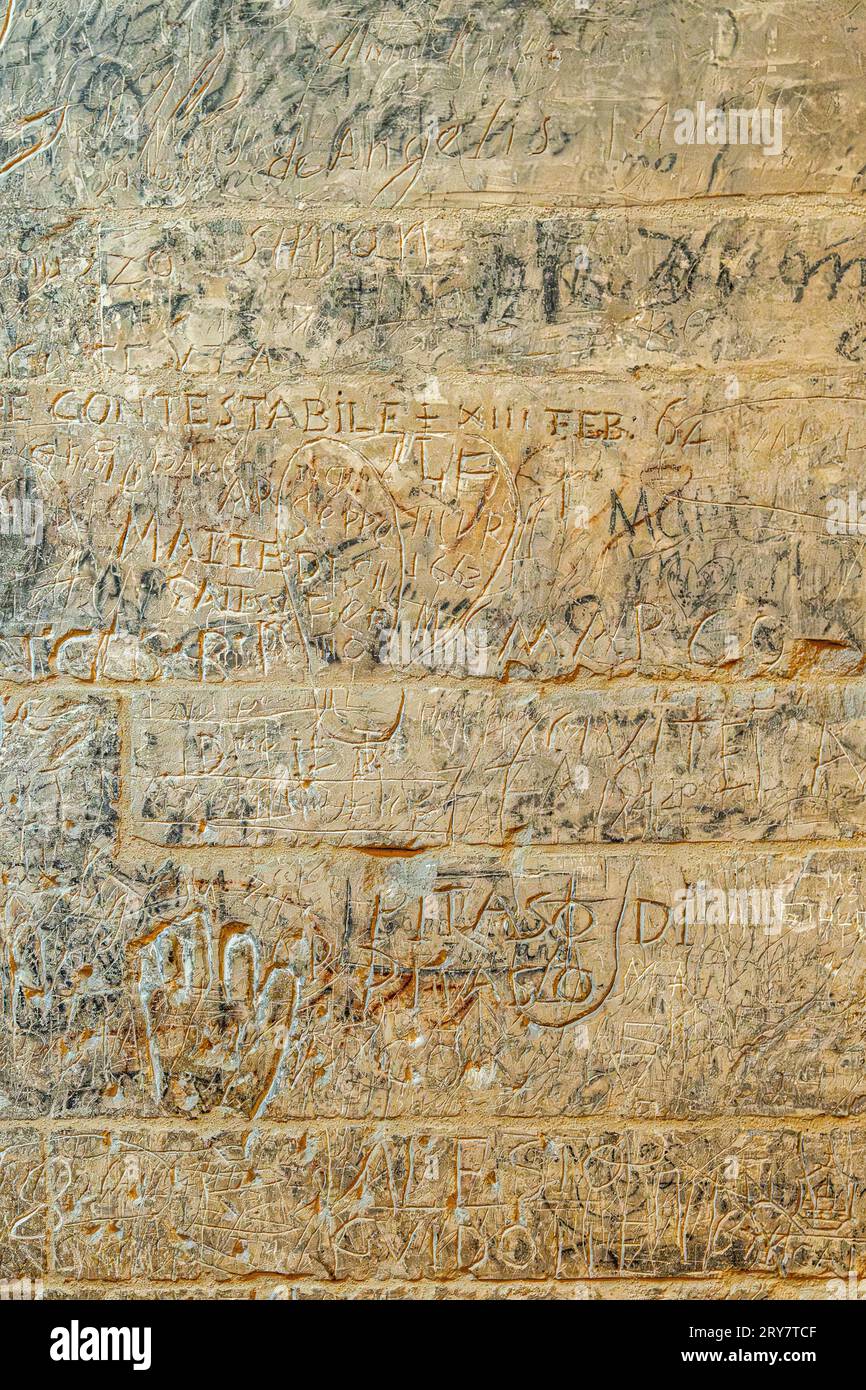 Grabados, escritos y textos devocionales e históricos a lo largo de los escalones que conducen a la cueva del Santuario de San Michele Arcangelo. Puglia Foto de stock