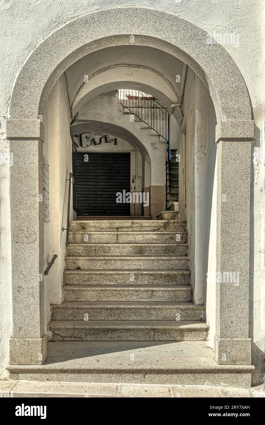 Patio interior de un palacio noble con acceso desde un pasaje cubierto con escalones y pórticos. Monte Sant'Angelo, provincia de Foggia, Italia, Europa Foto de stock