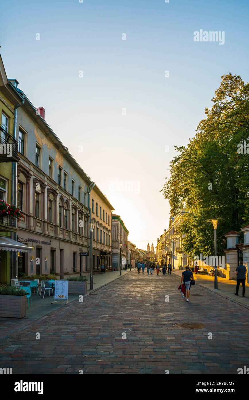 Kaunas, Lituania, 28 de septiembre de 2023, personas paseando por el distrito histórico de la ciudad al atardecer en otoño de luz naranja cálida disfrutando de ev cálido Foto de stock