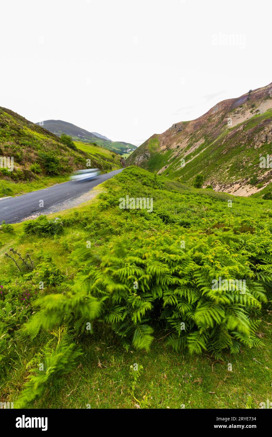 Carretera sobre el Sychnant Pass. O Bwlch Sychnant, Conwy, Gales Reino Unido, en Snowdonia o Eryri National Park, retrato, coche, borroso, lo que implica velocidad. Foto de stock