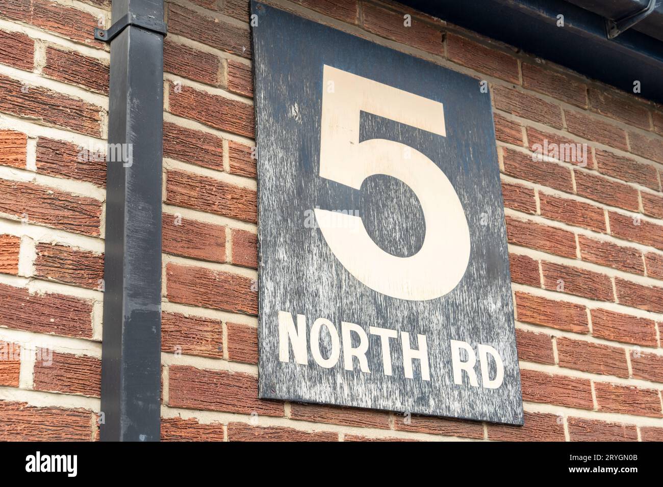 Un letrero de madera desgastado por el tiempo dice, 5 North Road Foto de stock