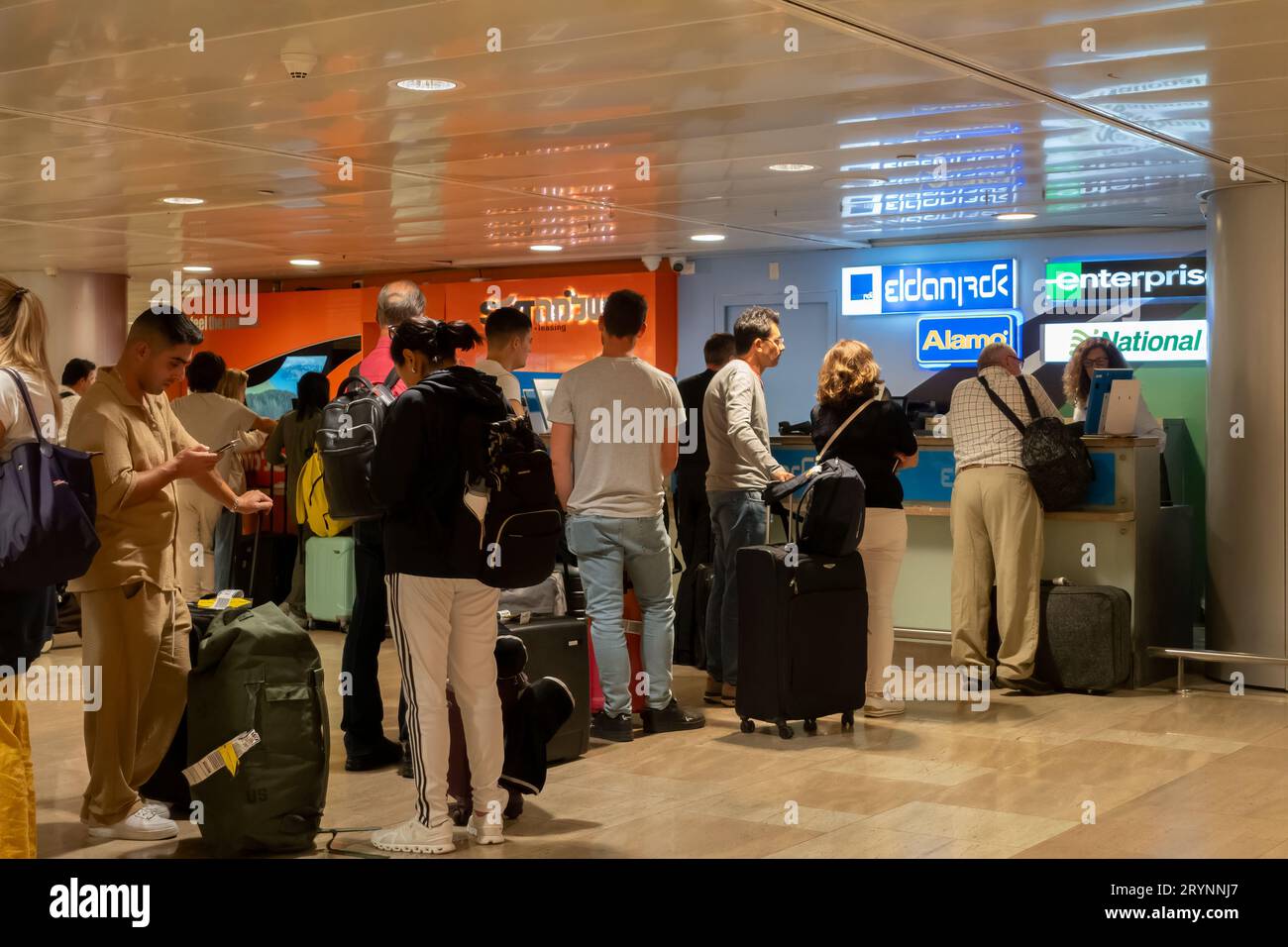 Los pasajeros esperan en la cola para alquilar un coche después de aterrizar en el aeropuerto internacional Ben Gurion cerca de Tel Aviv Israel Foto de stock