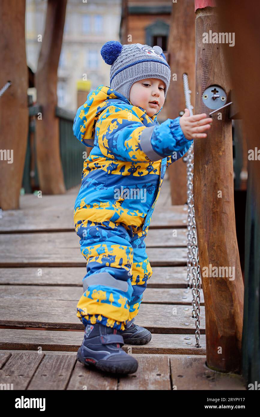 Retrato de un niño lindo jugando en el patio de recreo en invierno Foto de stock