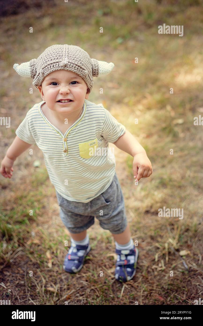 Retrato de un niño sonriente en un sombrero y camisa a rayas Foto de stock