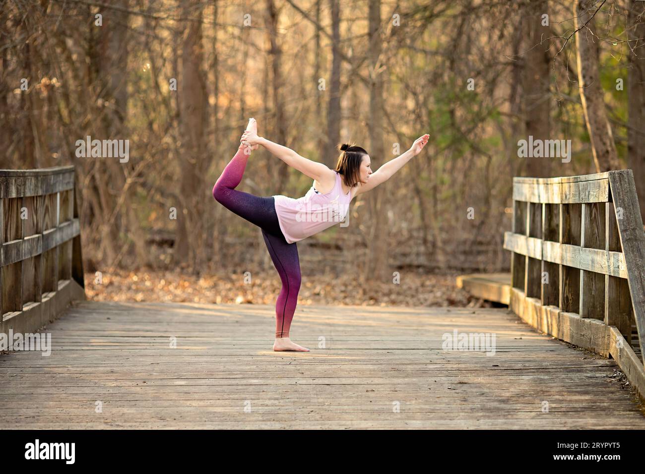 Mujer practicando yoga en un puente descalzo Foto de stock