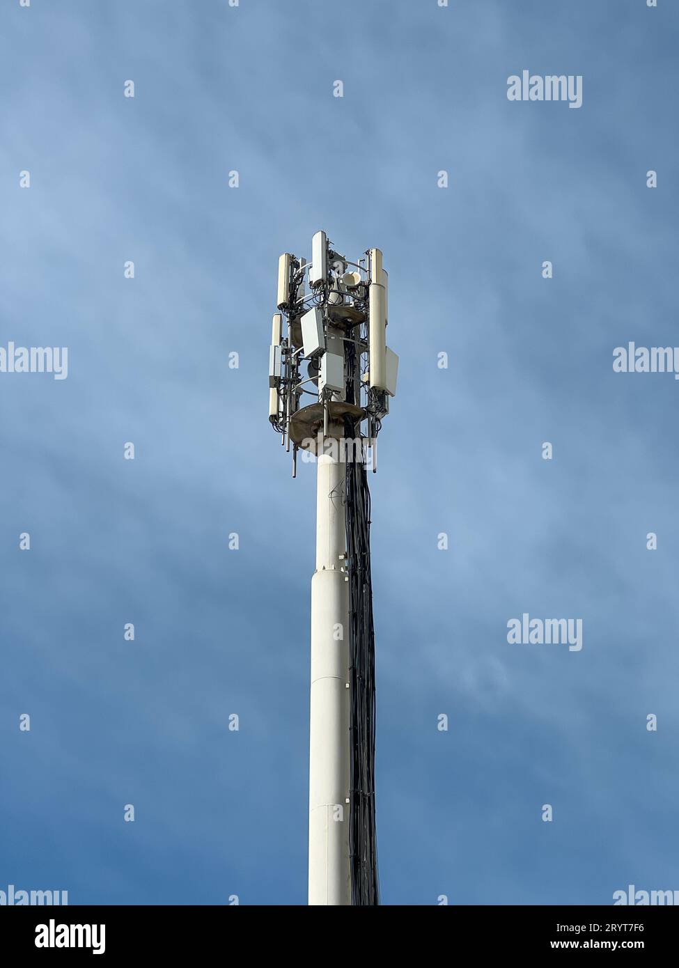 Estructura de torre de telecomunicaciones con múltiples antenas de transmisión y receptor con un fondo azul del cielo. Foto de stock