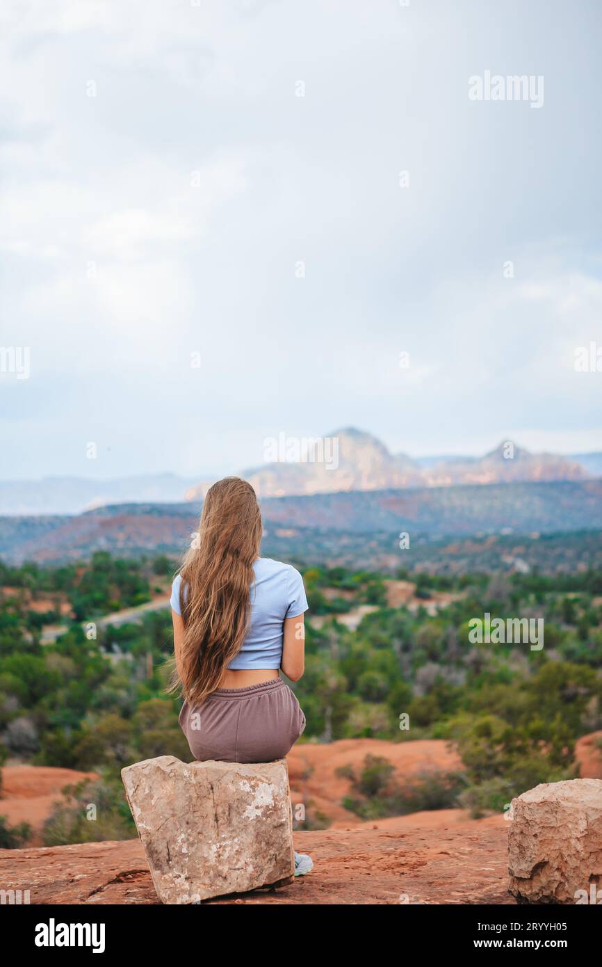 Chica disfruta de la vista del paisaje de Sedona desde la parte superior de la ruta de senderismo Bell Rock, famosa por sus numerosos vórtices de energía y. Foto de stock
