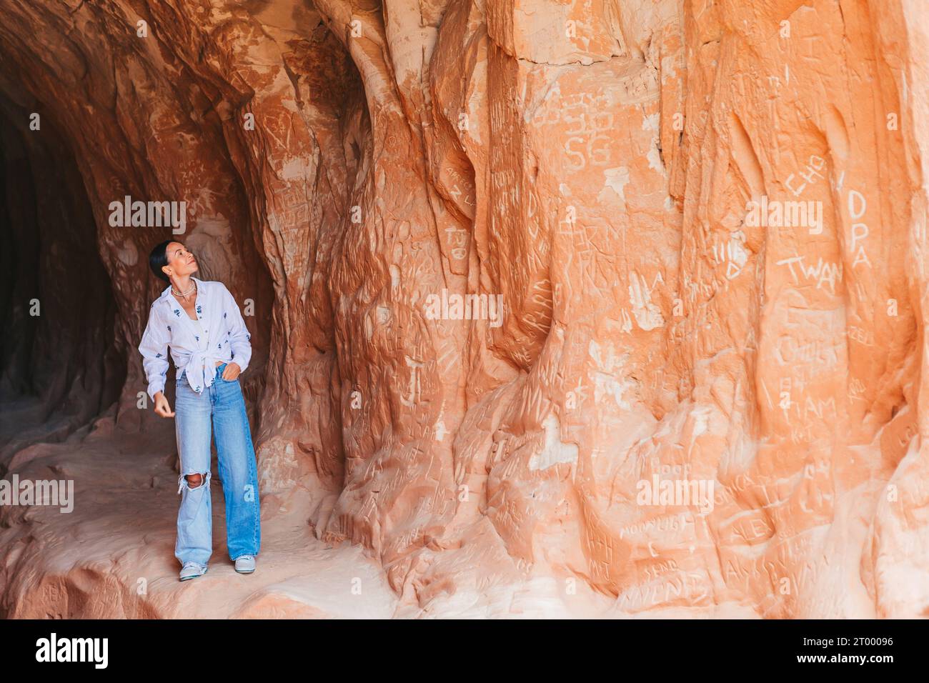 Mujer excursionista joven en el vientre popular del camino de la cueva del túnel del dragón en Kanab Foto de stock