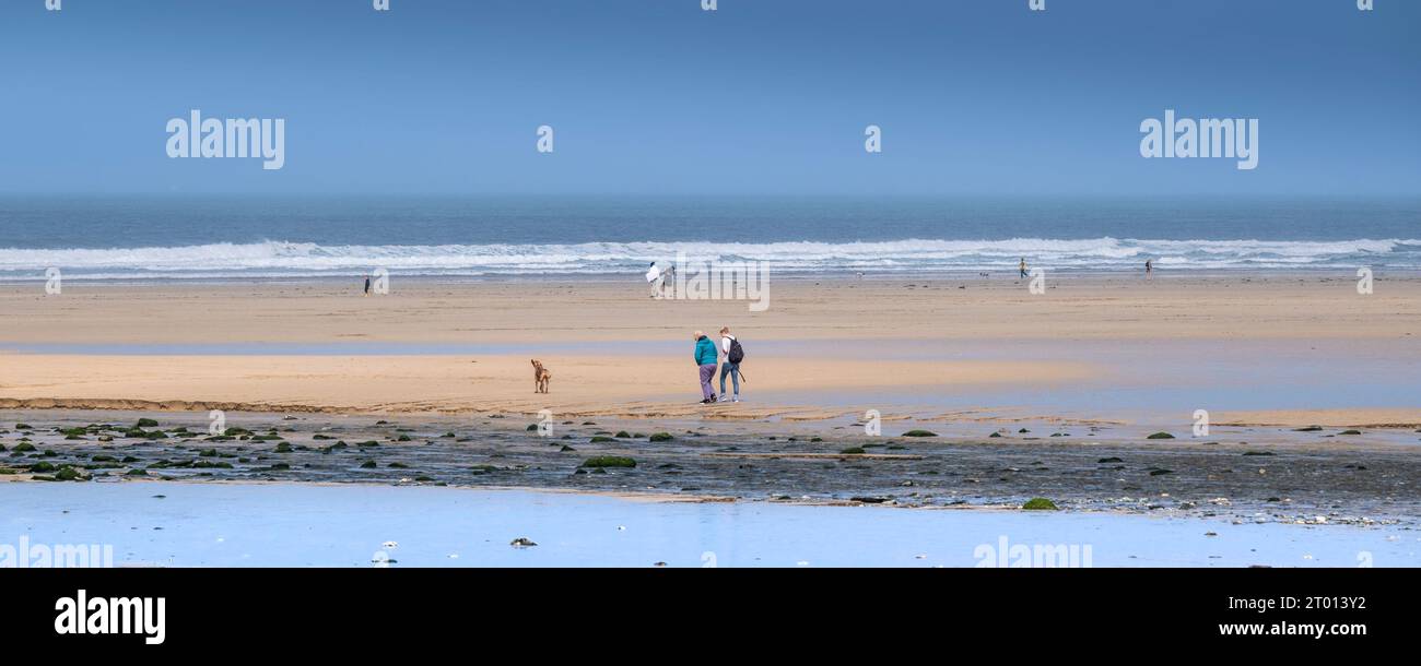 Una imagen panorámica de la gente disfrutando caminando en una tranquila playa de Mawgan Porth en Cornwall en el Reino Unido. Foto de stock