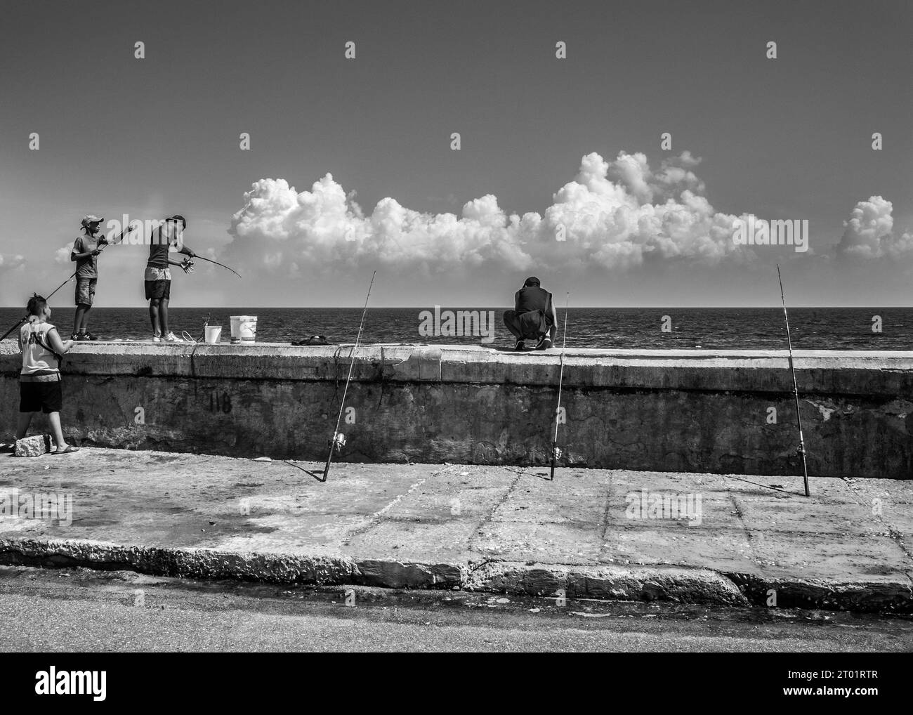 Niños pescando en la pared del mar Malecón Habana Cuba B/W Foto de stock