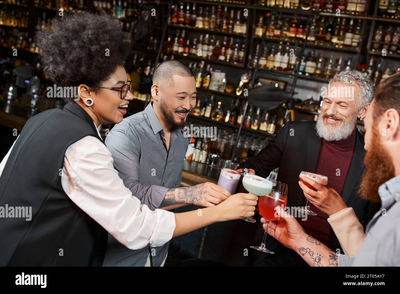 alegres amigos de trabajo multicultural tintineando copas de cóctel en el bar, ocio y diversión después del trabajo Foto de stock