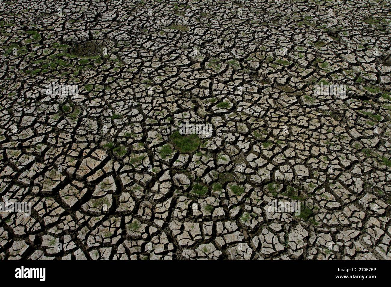 Wonogiri, Java Central, Indonesia. 6º de octubre de 2023. El suelo agrietado se puede ver en el secado del embalse de Gajah Mungkur, distrito de Wuryantoro. Se prevé que la estación seca de este año dure más, es decir, hasta finales de 2023 hasta principios de 2024, que es el impacto de El Niño. Actualmente, en medio de la amenaza de la sequía, el volumen de agua cruda del embalse de Gajah Mungkur en la parte superior del río Bengawan Solo en la regencia Wonogiri, Java Central ha disminuido drásticamente. (Imagen de crédito: © Angga Budhiyanto/ZUMA Press Wire) ¡USO EDITORIAL SOLAMENTE! ¡No para USO comercial! Foto de stock