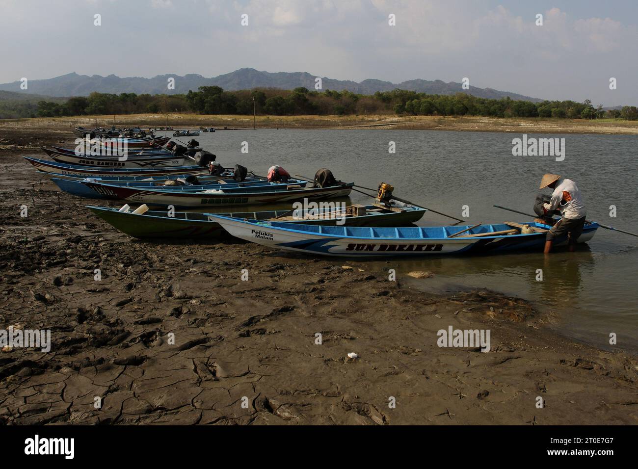 Wonogiri, Java Central, Indonesia. 6º de octubre de 2023. Un pescador prepara un barco en el secado del embalse de Gajah Mungkur, distrito de Wuryantoro. Se prevé que la estación seca de este año dure más, es decir, hasta finales de 2023 hasta principios de 2024, que es el impacto de El Niño. Actualmente, en medio de la amenaza de la sequía, el volumen de agua cruda del embalse de Gajah Mungkur en la parte superior del río Bengawan Solo en la regencia Wonogiri, Java Central ha disminuido drásticamente. (Imagen de crédito: © Angga Budhiyanto/ZUMA Press Wire) ¡USO EDITORIAL SOLAMENTE! ¡No para USO comercial! Foto de stock