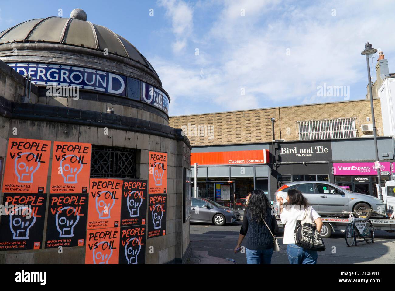 Londres, Reino Unido. 6º de octubre de 2023. Carteles de color naranja brillante y negro con el eslogan 'People vs oil' han sido enyesados en el exterior de la estación de metro Clapham Common por el grupo de campaña ambiental Just Stop Oil. El grupo está planeando una serie de protestas pacíficas a partir del 29 de octubre. Crédito: Anna Watson/Alamy Live News Foto de stock