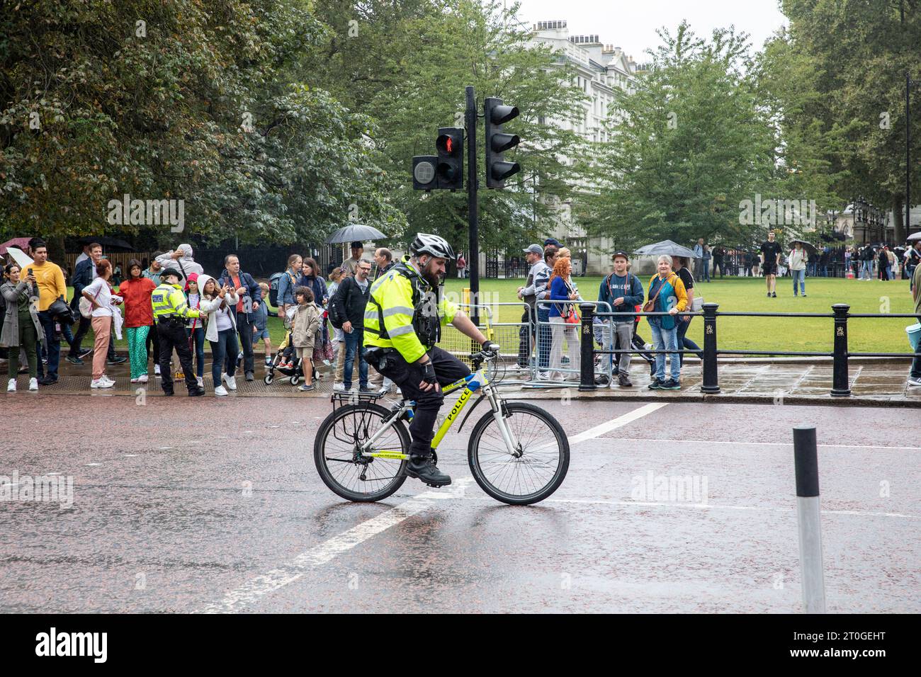 Oficial de policía de Londres montando bicicleta de policía como parte del control de multitudes en el Palacio de Buckingham durante el cambio de guardia, Londres, Inglaterra, Reino Unido Foto de stock