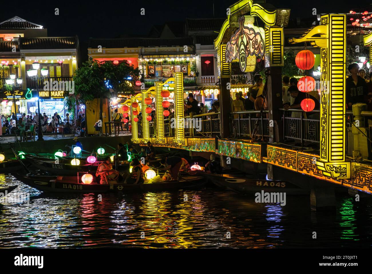 Hoi An, Vietnam. Puente peatonal y barcos turísticos en el río Thu Bon por la noche. Foto de stock