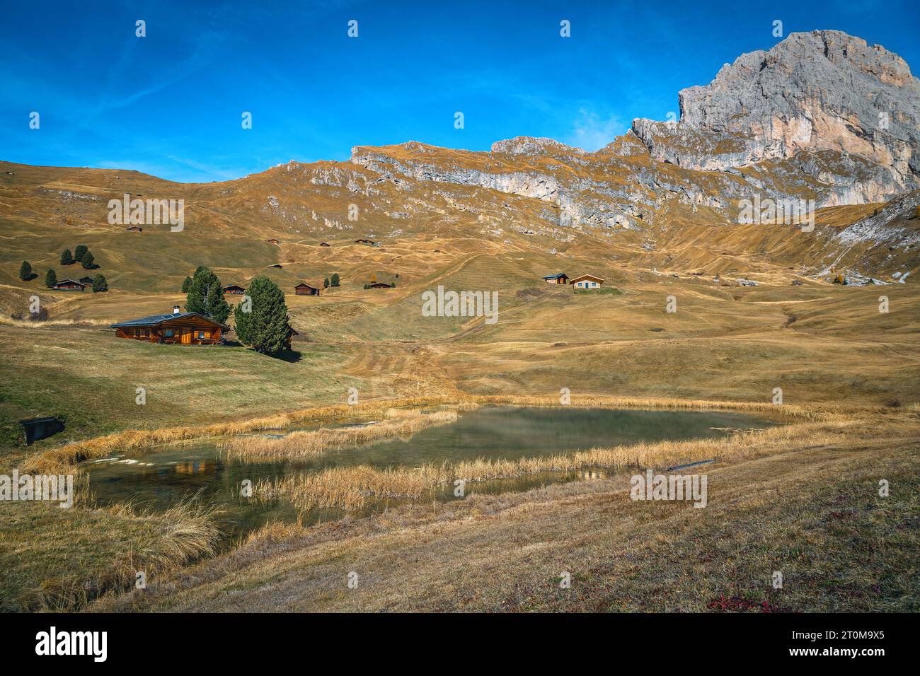 Pequeñas casas de madera lindas y lago alpino en el pasto de montaña, grupo de montaña Puez-Odle, Dolomitas, Italia, Europa Foto de stock