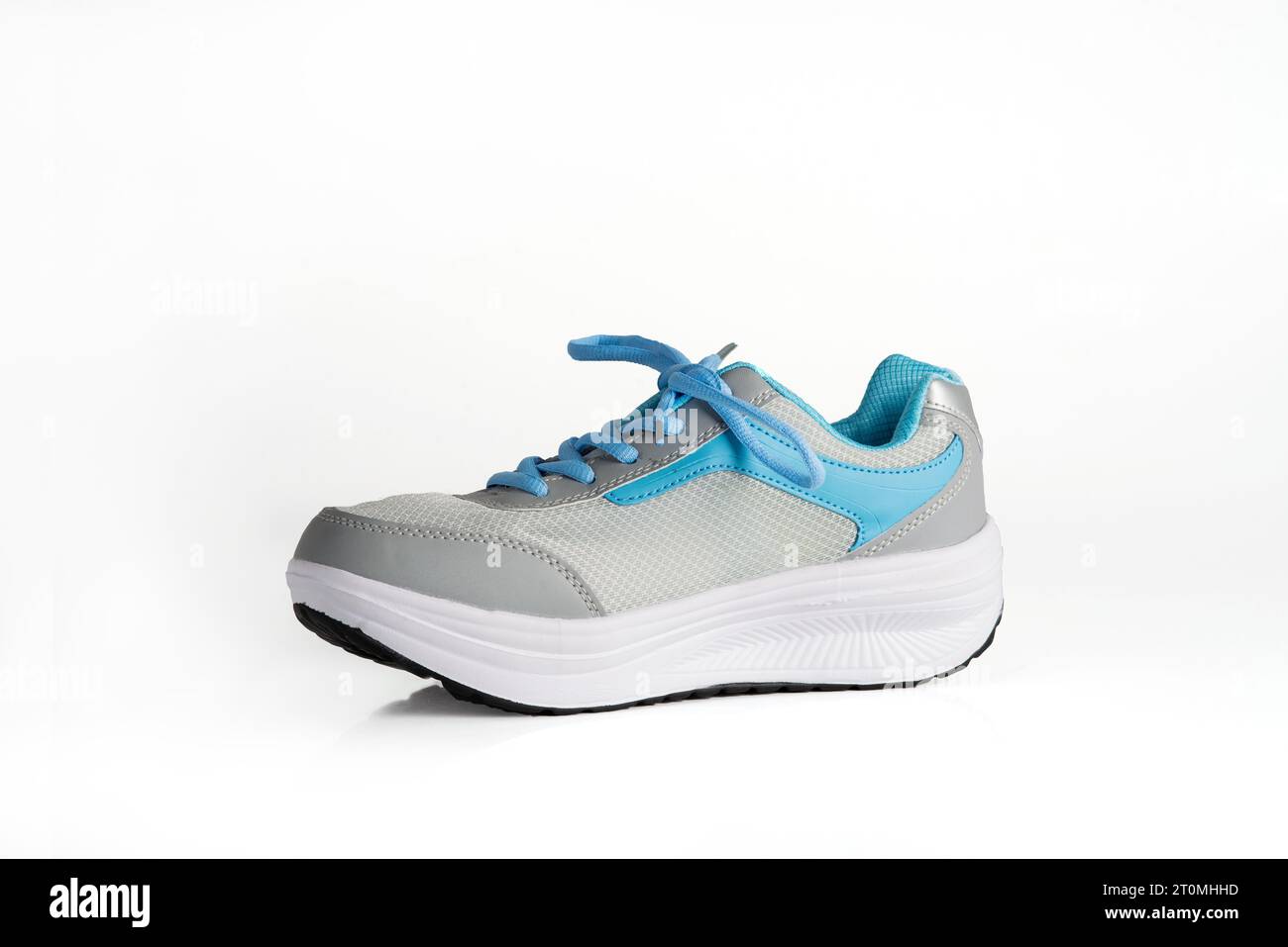 Un par de zapatillas para correr para mujer con zapatos coloridos sobre una  superficie reflectante.