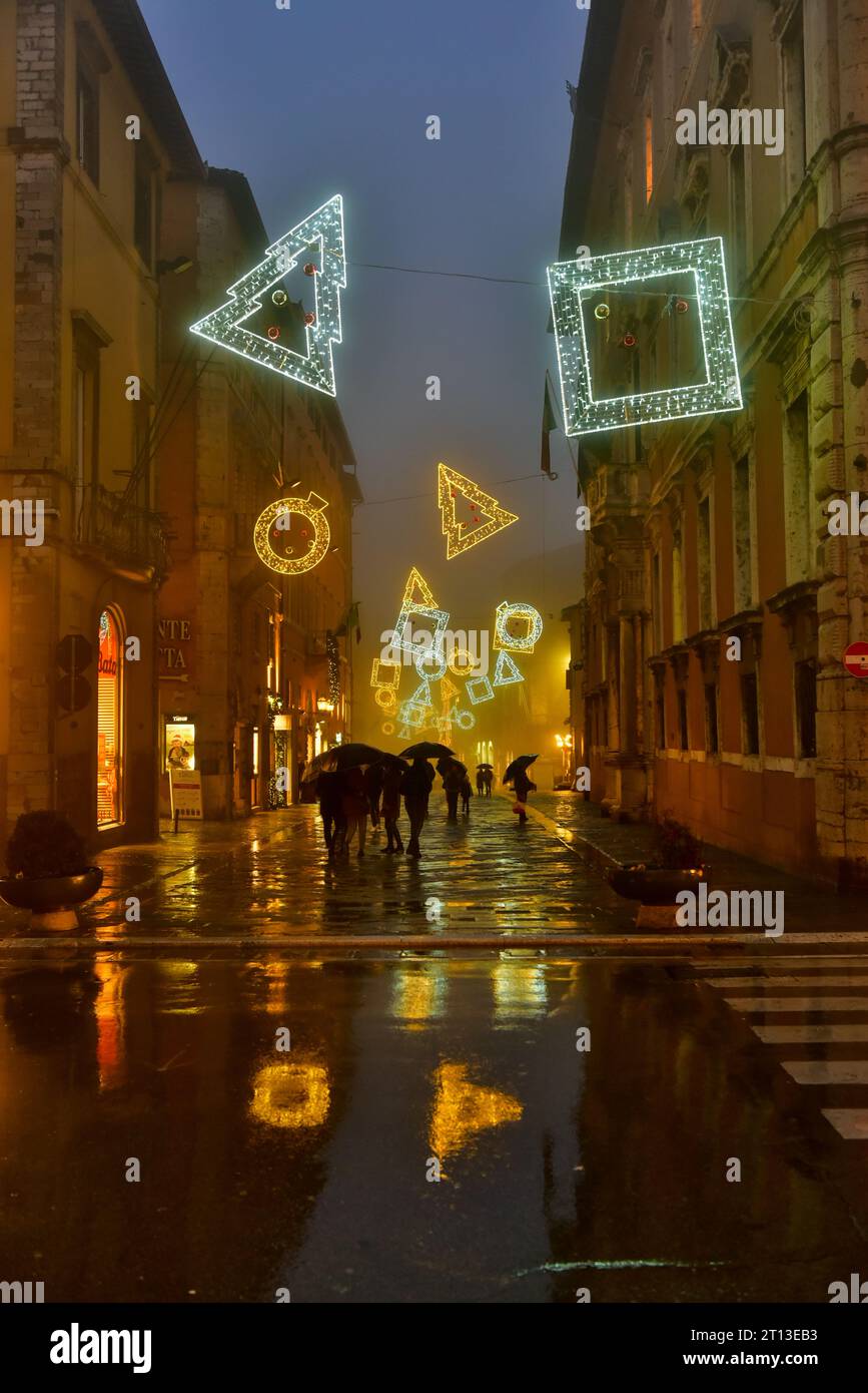 Las luces navideñas y su imagen de espejo en Corso Pietro Vannucci desde Piazza Italia. Filmada en una noche lluviosa en Perugia, Italia Foto de stock