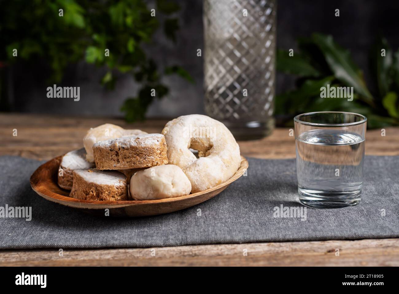 Pan corto, donuts de vino y bollería de hojaldre en un plato de madera y  junto a un vaso pequeño con anís Fotografía de stock - Alamy