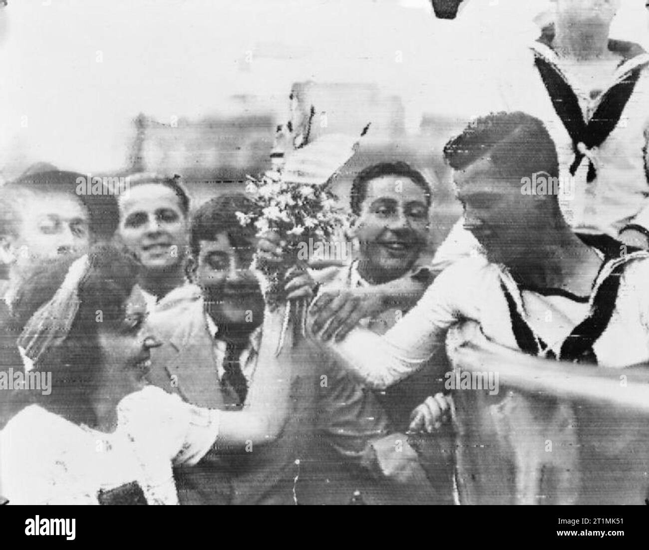 La Royal Navy durante la Segunda Guerra Mundial, los marineros, posiblemente del crucero HMS AJAX, paseo por las calles de Montevideo después de la batalla del río de La Plata y el echar a pique del Almirante Graf Spee. Aquí uno de ellos se presenta con un ramo de flores por una mujer. Foto de stock