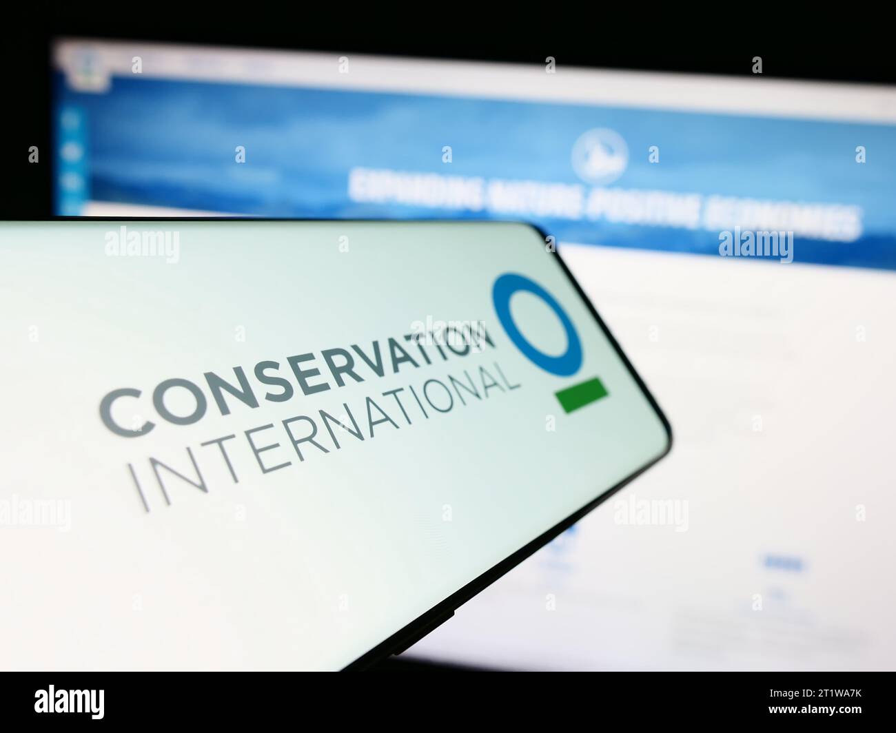Smartphone con el logotipo de la organización ambiental Conservation International (CI) delante del sitio web. Enfoque en el centro de la pantalla del teléfono. Foto de stock
