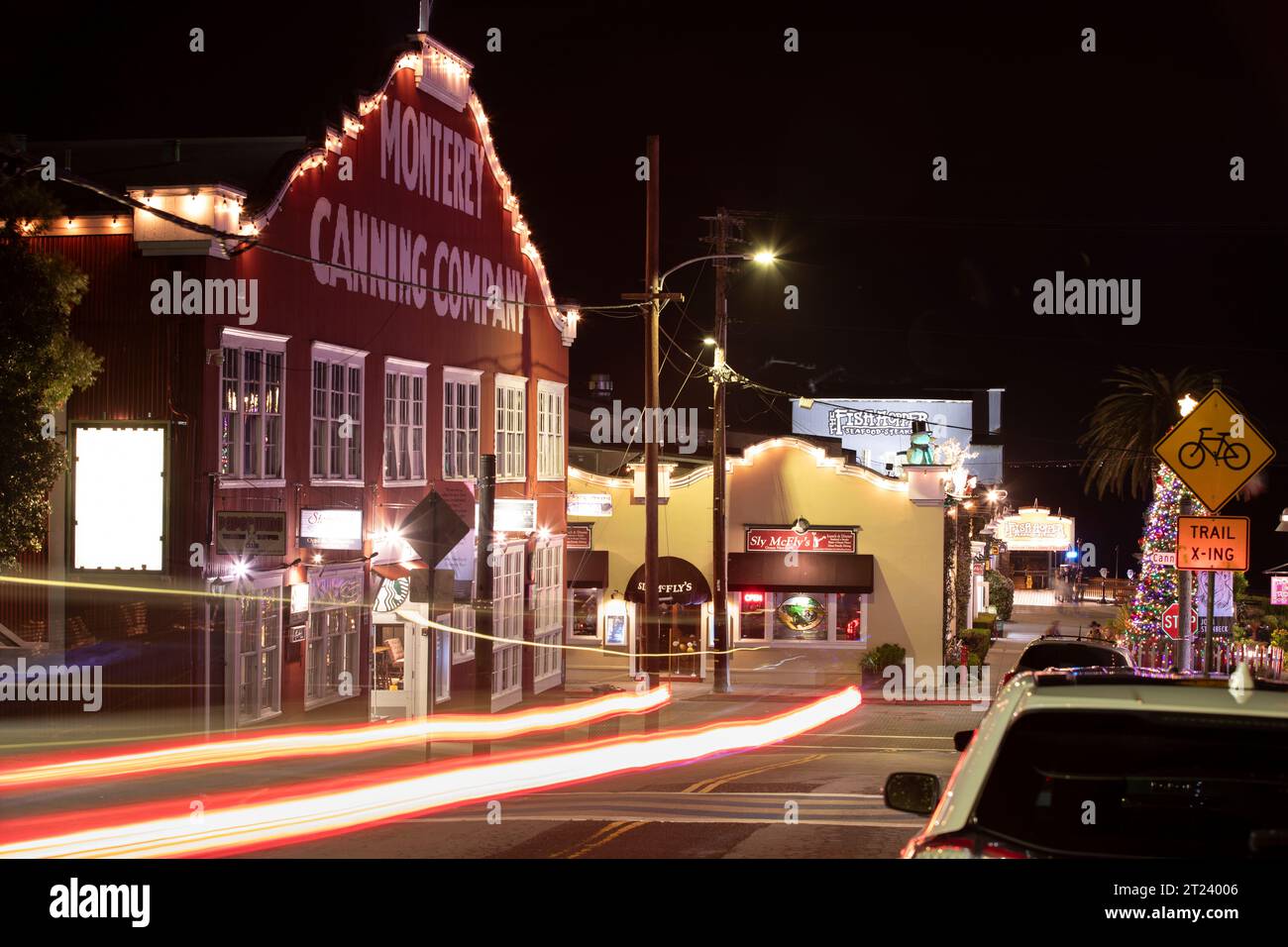 Monterey, California, EE.UU. - 31 de diciembre de 2022: El tráfico nocturno pasa a través de la histórica Cannery Row. Foto de stock