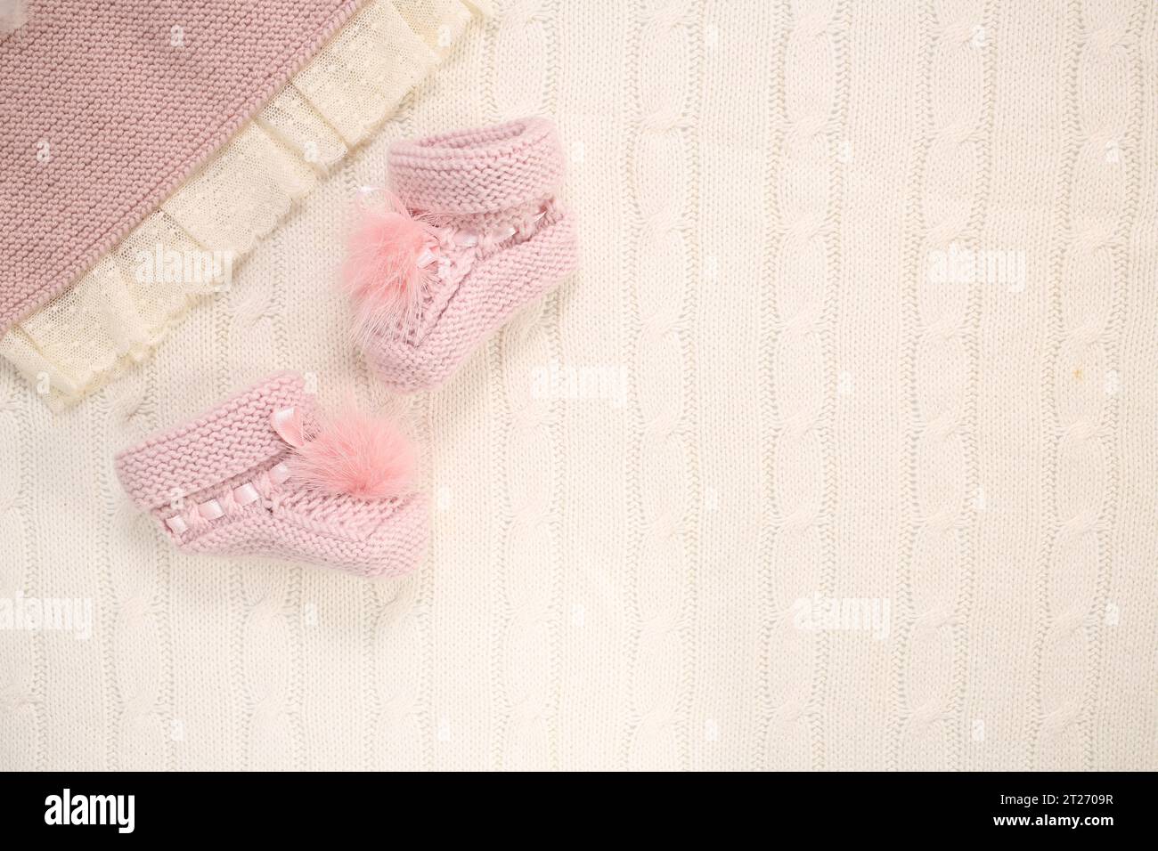 Par de calcetines de bebé pequeños sobre fondo rosa con espacio de copia para su mensaje cálido. Foto de stock