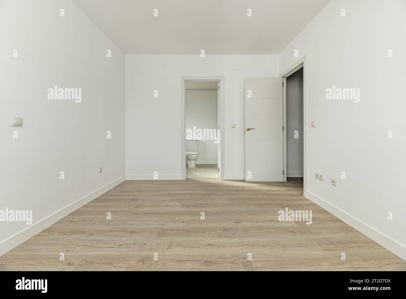 Dormitorio vacío de una casa unifamiliar con baño en suite, suelos de madera Foto de stock
