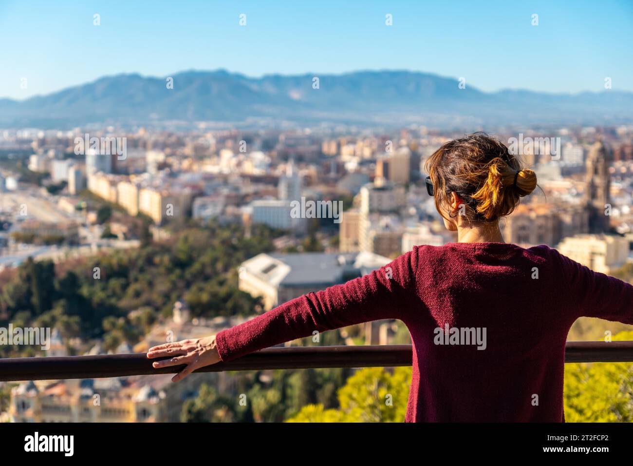 Un joven turista mirando las vistas de la ciudad y la Catedral de la Encarnación de Málaga desde el Castillo de Gibralfaro en la ciudad de Málaga Foto de stock