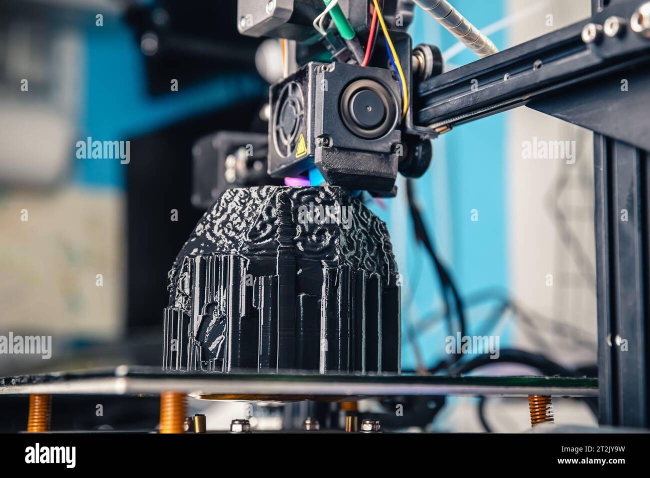 Una impresora 3D imprime un modelo negro. Tecnología en casa Foto de stock
