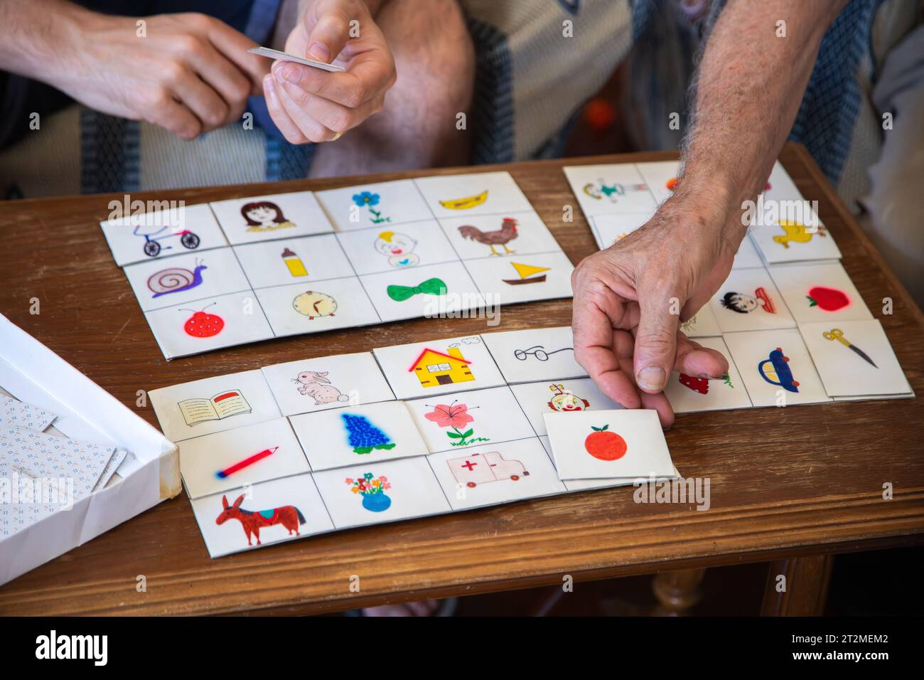 Juega con los más jóvenes. Actividades de ocio entre abuelos y nietos. Actividades en familia, juegos de mesa. Foto de stock