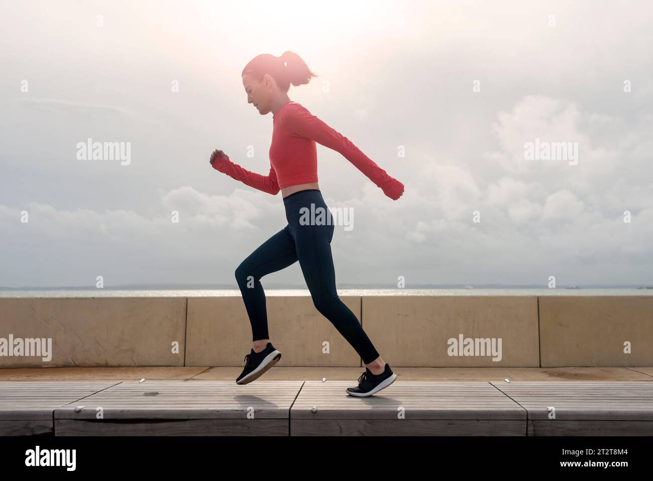 Mujer deportiva corriendo y trotando, entrenamiento al aire libre. Foto de stock