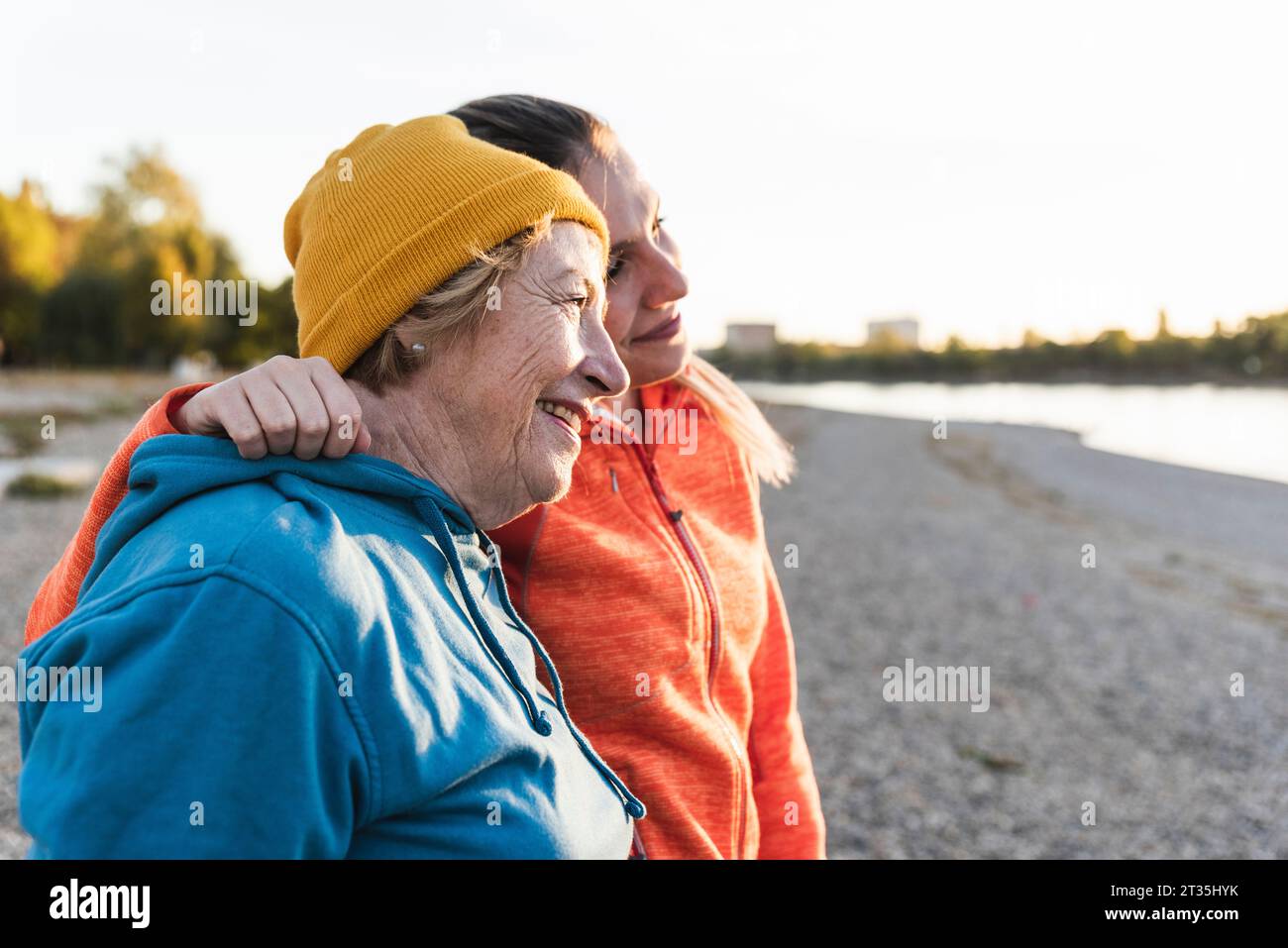 Colocar abuela y nieta caminando en el río con los brazos alrededor, divertirse Foto de stock