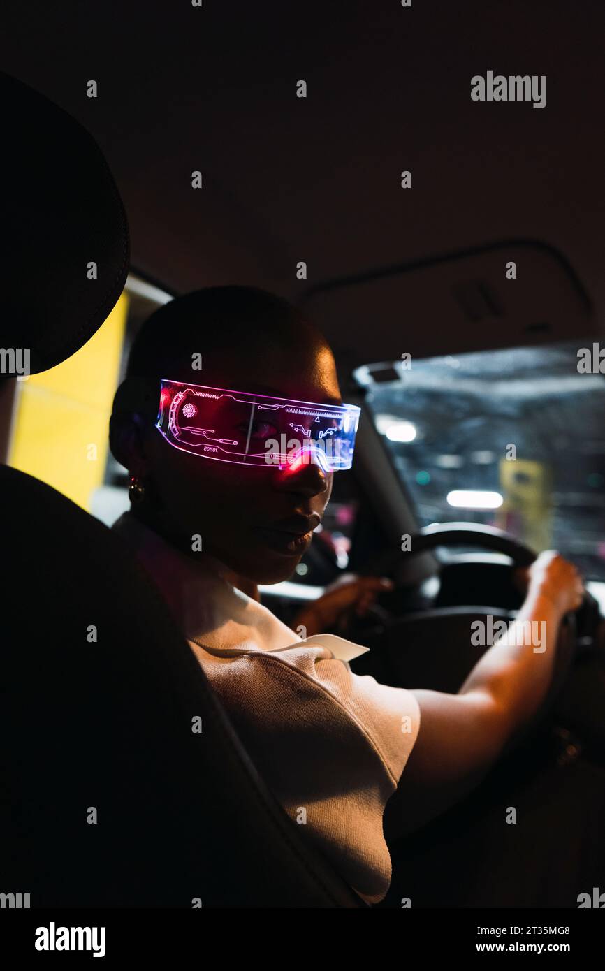 Empresaria con gafas inteligentes y sentado en el coche Foto de stock