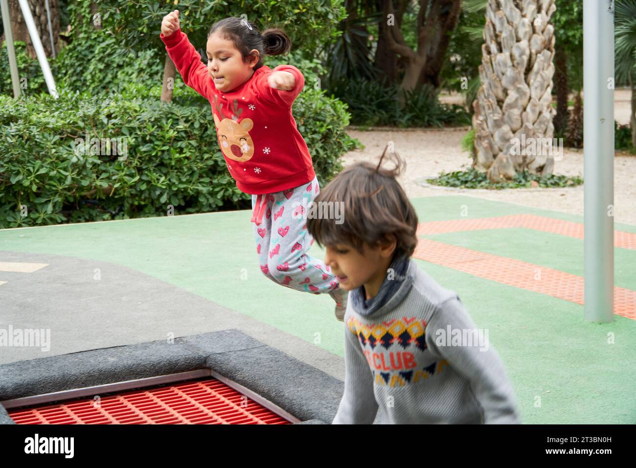 Niños multirraciales saltando en trampolín en las vacaciones de Navidad Foto de stock