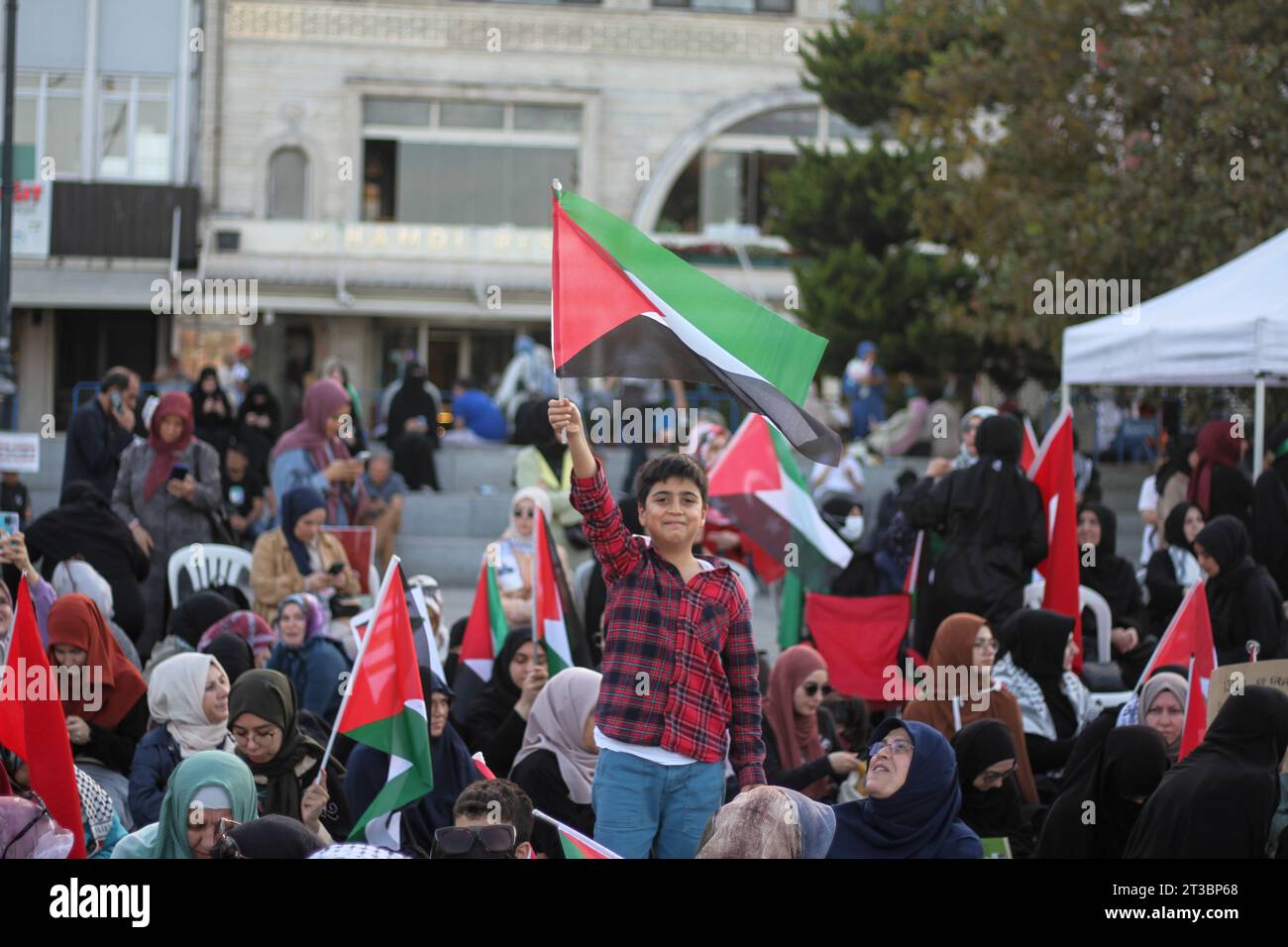 Estambul, Turquía. 22 de octubre de 2023. Un niño ondea la bandera palestina durante la manifestación. Las mujeres organizaron una sentada de protesta, en solidaridad con Gaza en la zona turística de Eminonu en Estambul. Se presentaron folletos de concientización sobre los acontecimientos actuales en Gaza, y se exhibieron imágenes de la ciudad y los acontecimientos que tuvieron lugar allí. (Foto de Muhmmad Al-Najjar/SOPA Images/Sipa USA) Crédito: SIPA USA/Alamy Live News Foto de stock