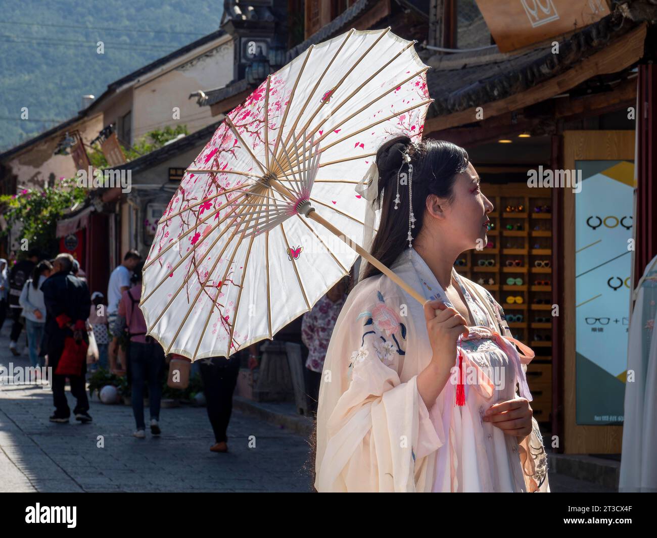 Mujer en la nostalgia china, sombrilla y viejo vestido lujoso, histórico casco antiguo de Dali, Yunnan, China Foto de stock