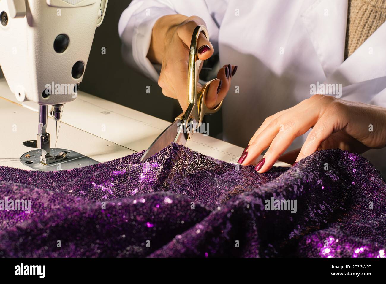 Manos a la medida en el trabajo en la máquina de coser y tijeras primer plano diseñador de moda en el lugar de trabajo Foto de stock