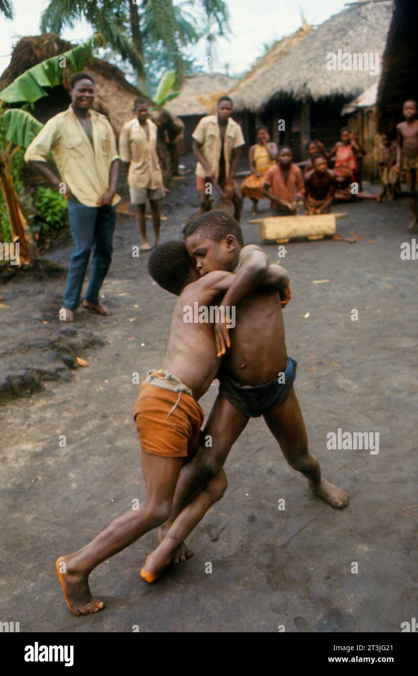 Chicos de la etnia Libinza interpretando la tradicional lucha pongo al ritmo de los tambores. Zona del río Ngiri, República Democrática del Congo, África Foto de stock