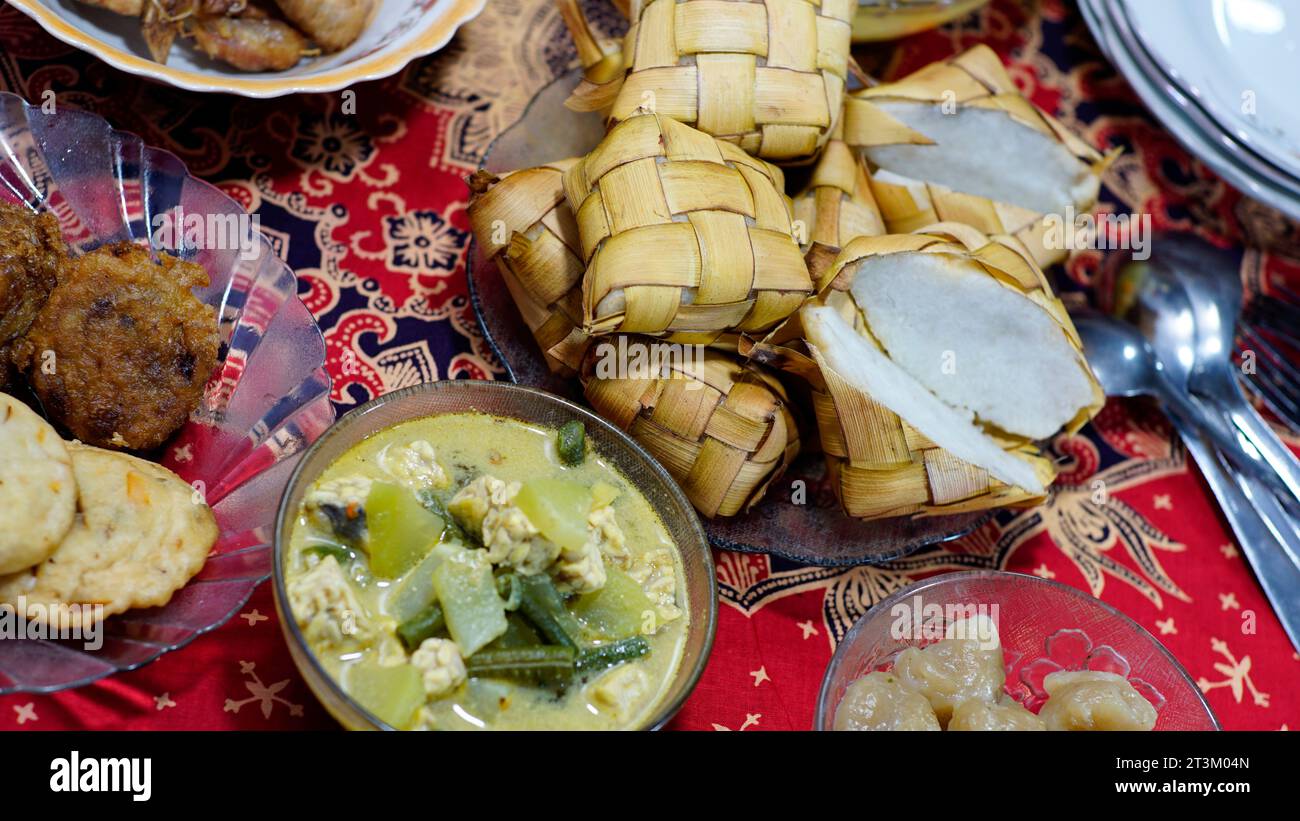 ketupat de verduras y varios platos de acompañamiento simples en la mesa. Foto de stock