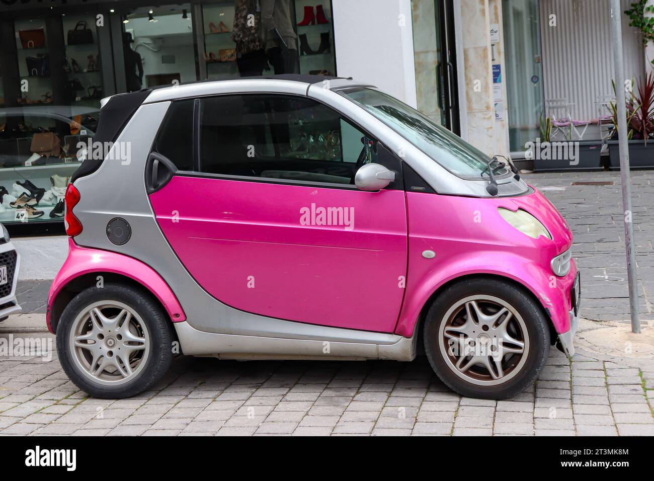 Smart Fortwo de color rosa brillante, un coche urbano de dos plazas construido por la división Smart del Grupo Mercedes-Benz Foto de stock