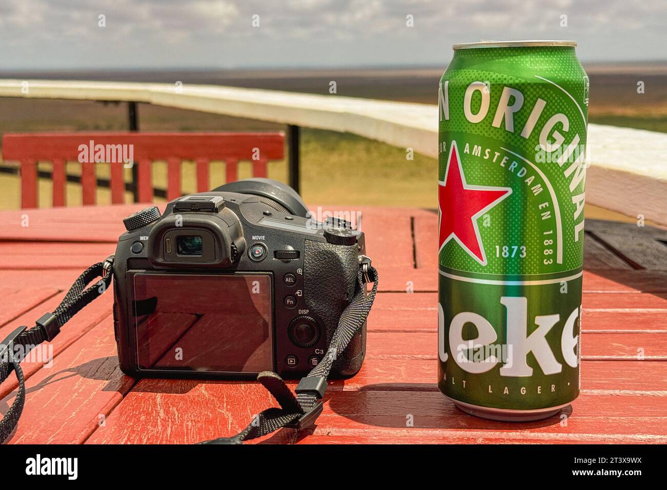 Una cerveza heineken puede junto a una cámara digital en un punto de vista escénico en Tsavo East Nationa Park, Kenia Foto de stock