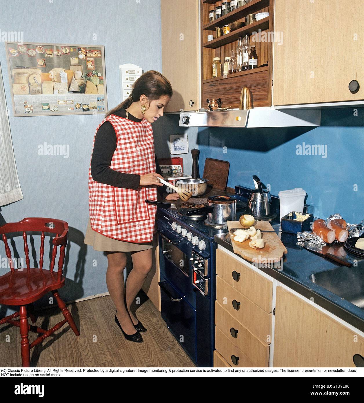 En la cocina de los años setenta. La actriz, cantante Lill-Babs Svensson, fotografiada en la cocina típica de los setenta cocinando una comida. Suecia 1972. A cargo de Kristoffersson Foto de stock