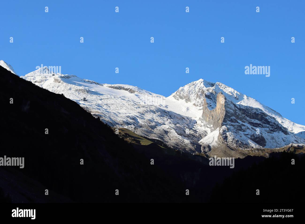 Picos nevados de las montañas brillan en el sol de la mañana, glaciar Hinterux, espacio de copia Foto de stock