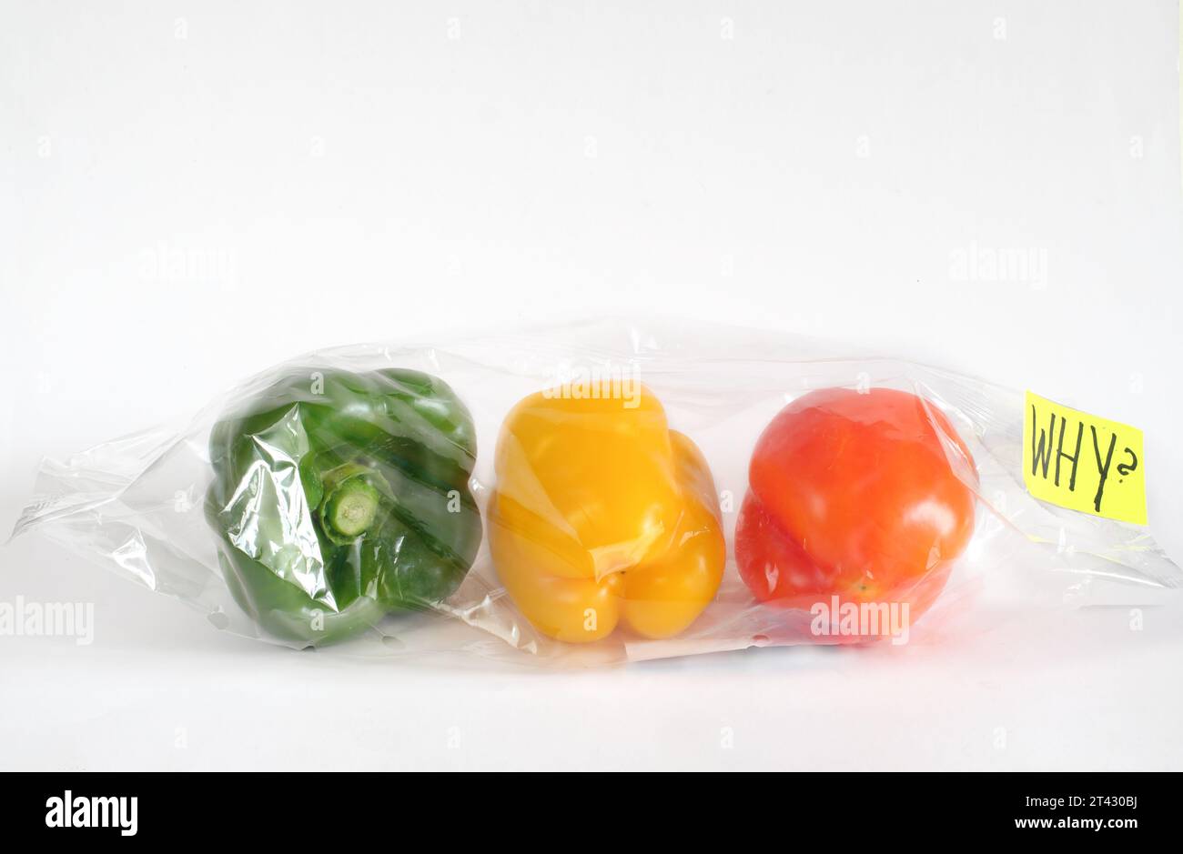 Concepto de alimentos envueltos en plástico contaminante, pimientos en una bolsa de plástico y firma con la leyenda '¿Por qué?' concepto de conservación ambiental Foto de stock