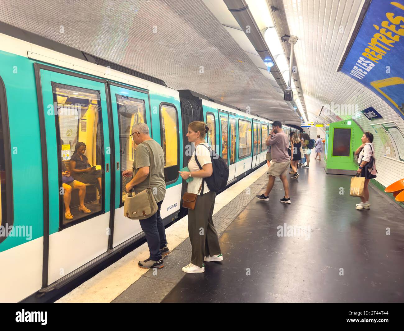 Pasajeros que suben al tren en la plataforma, estación de metro Blanche, Clichy Boulevard, Montmartre, París, Île-de-France, Francia Foto de stock